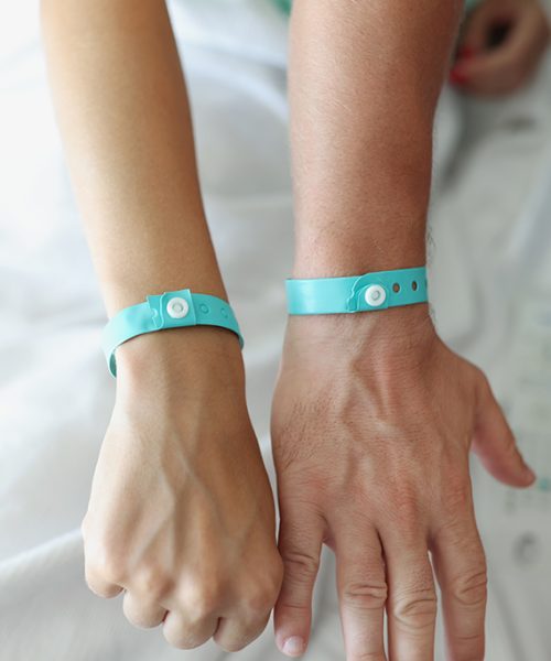 On the male and female hands a blue hotel bracelet, close-up, blurry. Loyalty program, visit to SPA and restaurant